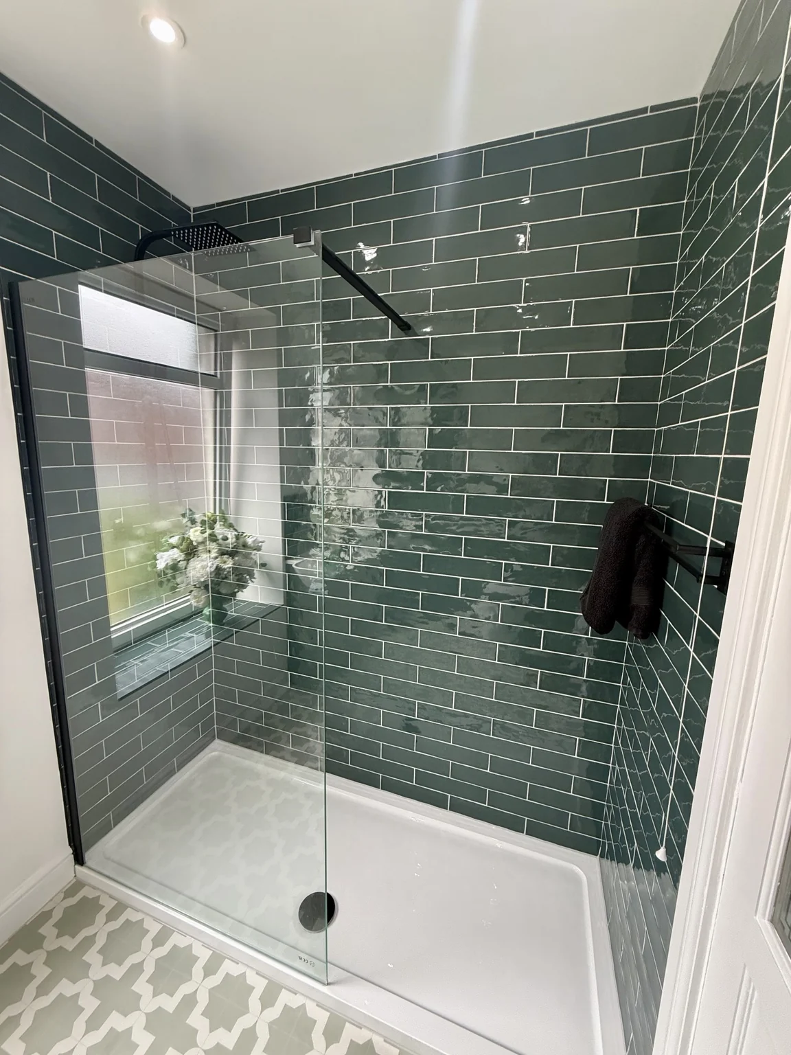 Green tiled shower enclosure with black fittings — completed DDI bathroom
